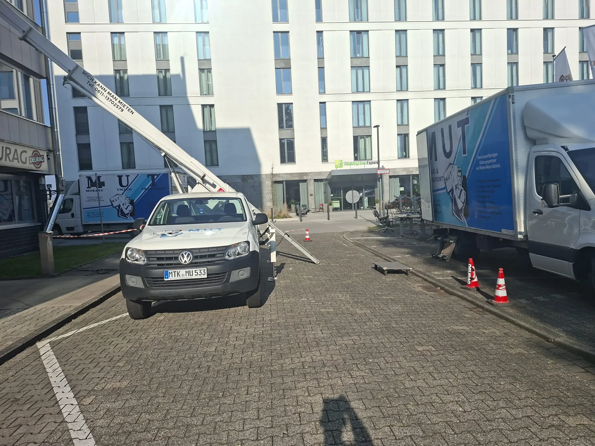 Möbellift und MUT-Umzugswagen vor einem Hotelgebäude