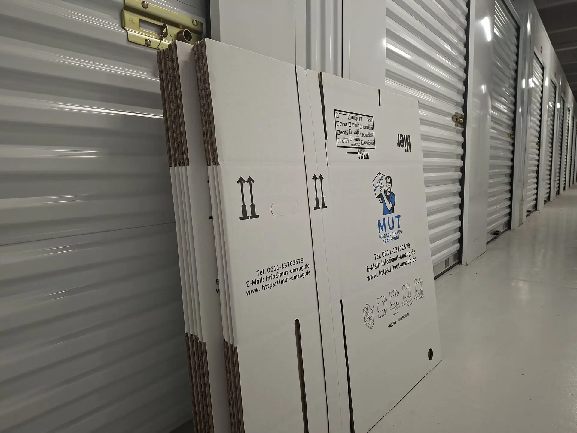 Zusammengefaltete MUT-Umzugskartons an der Wand einer Self-Storage-Box