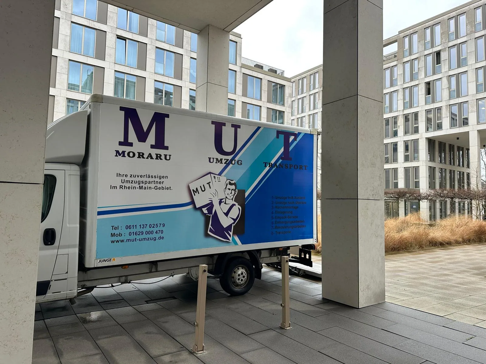 MUT-Umzugswagen vor einem neu gebauten Wohnquartier