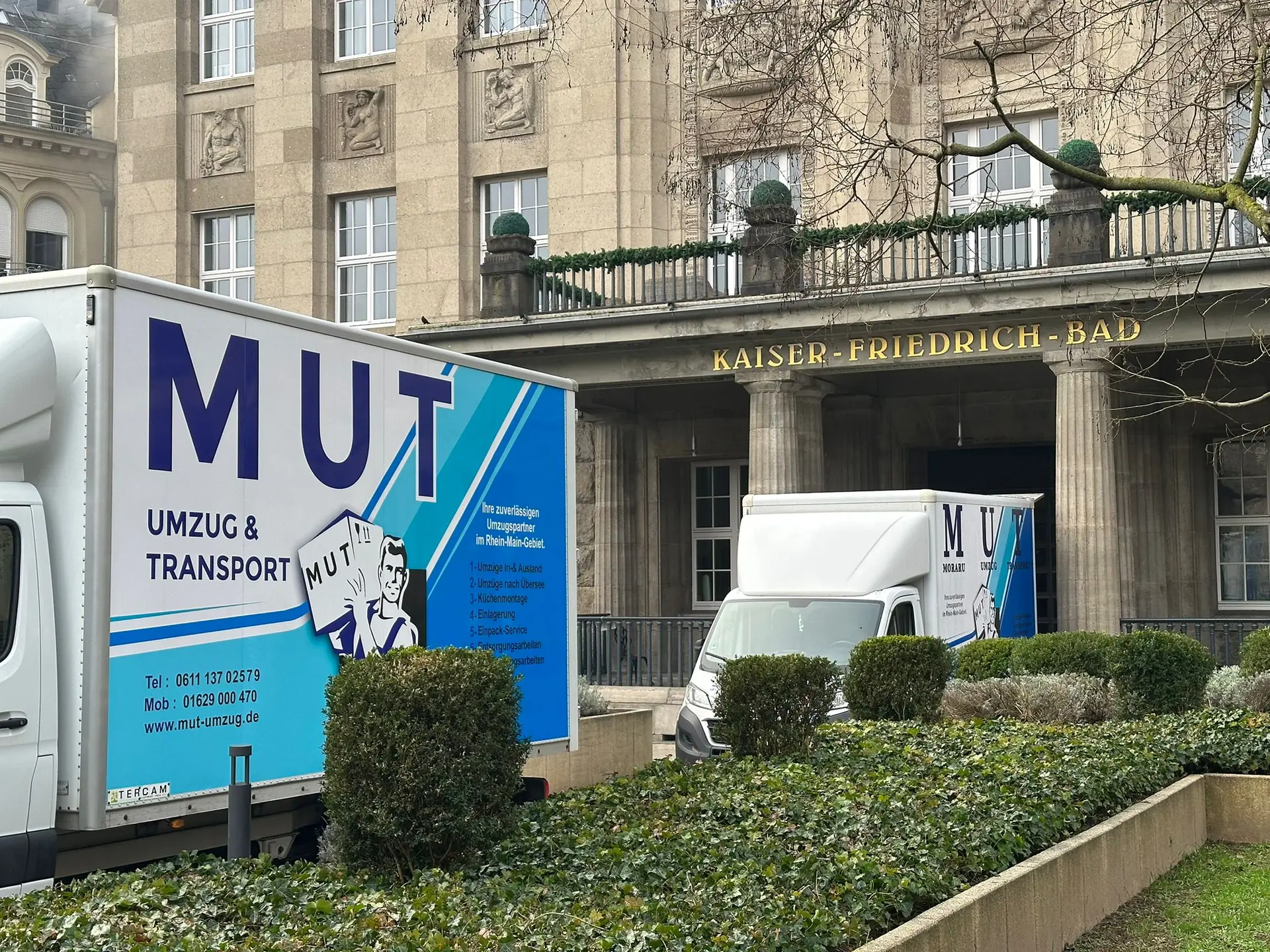 Zwei MUT-Umzugswagen vor dem Kaiser-Friedrich-Bad in Wiesbaden
