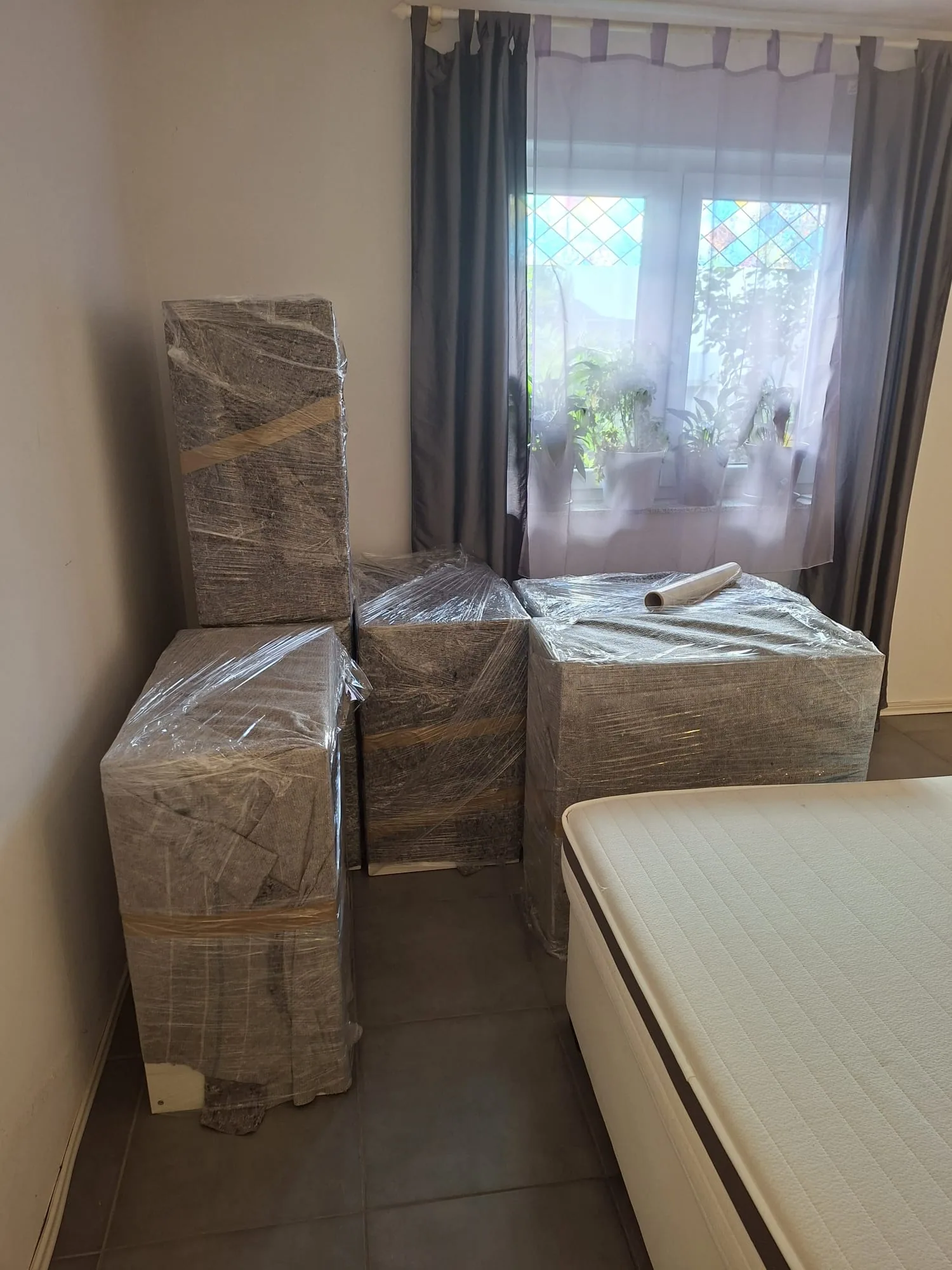In Folie verpackte Möbel in einem Schlafzimmer